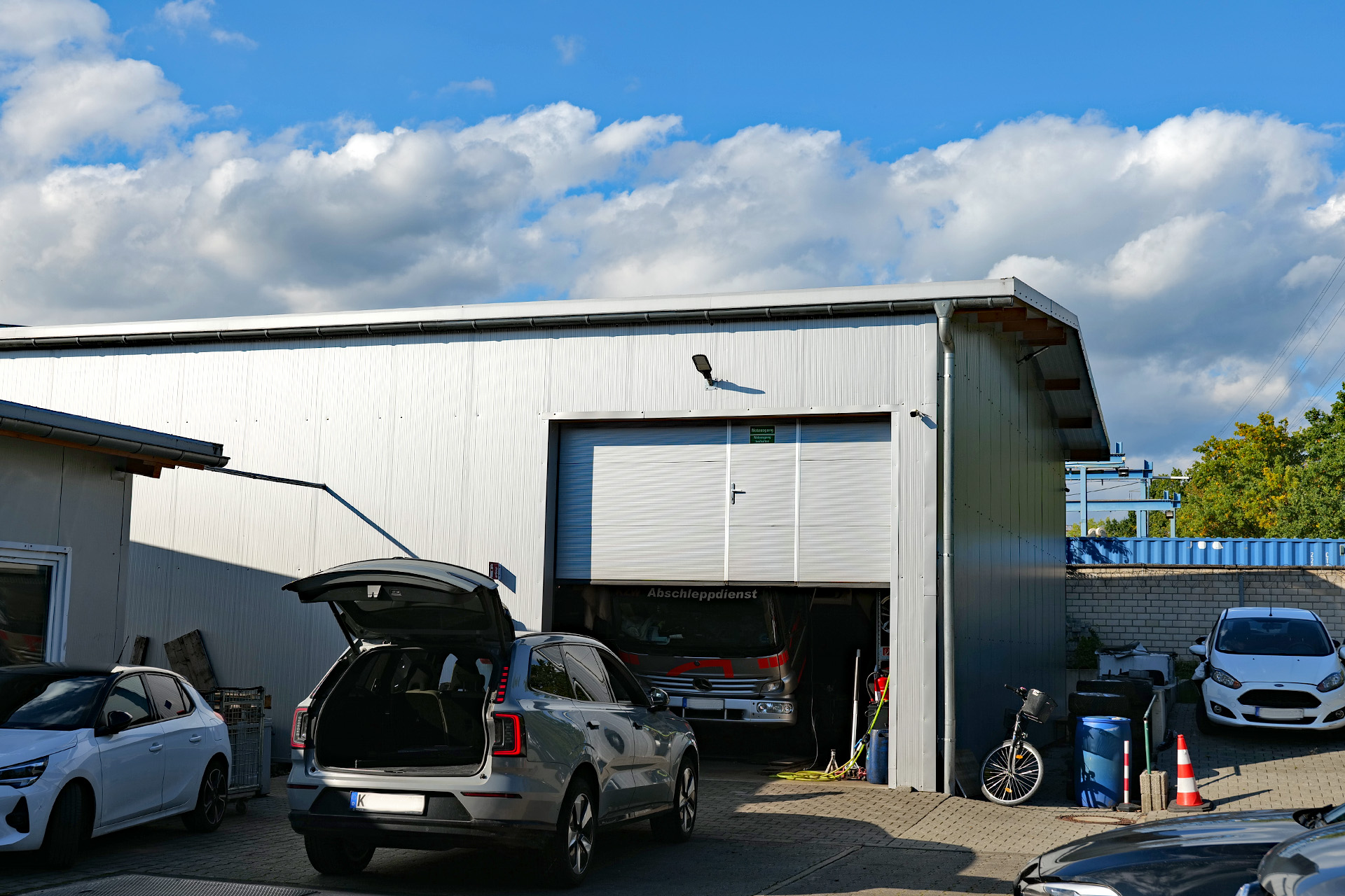 Sektionaltor mit Schlupftür und Doppelverglasung für eine Autowerkstatt in Wesseling, nahe dem Standort Bornheim der Christensen Tor- und Türsysteme GmbH.
