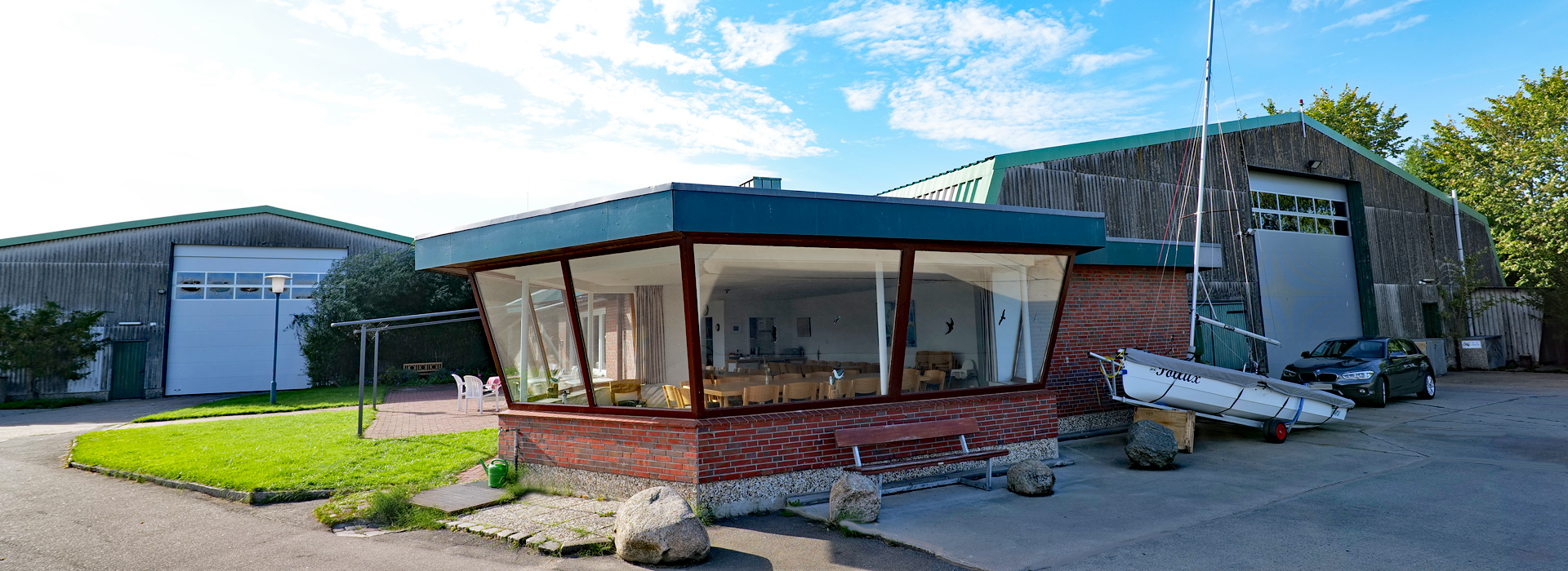 Die schöne Außenanlage des Yachtclubs am Sperrwerk Krückau mit zwei Sektionaltoren von Christensen in den Bootshallen.